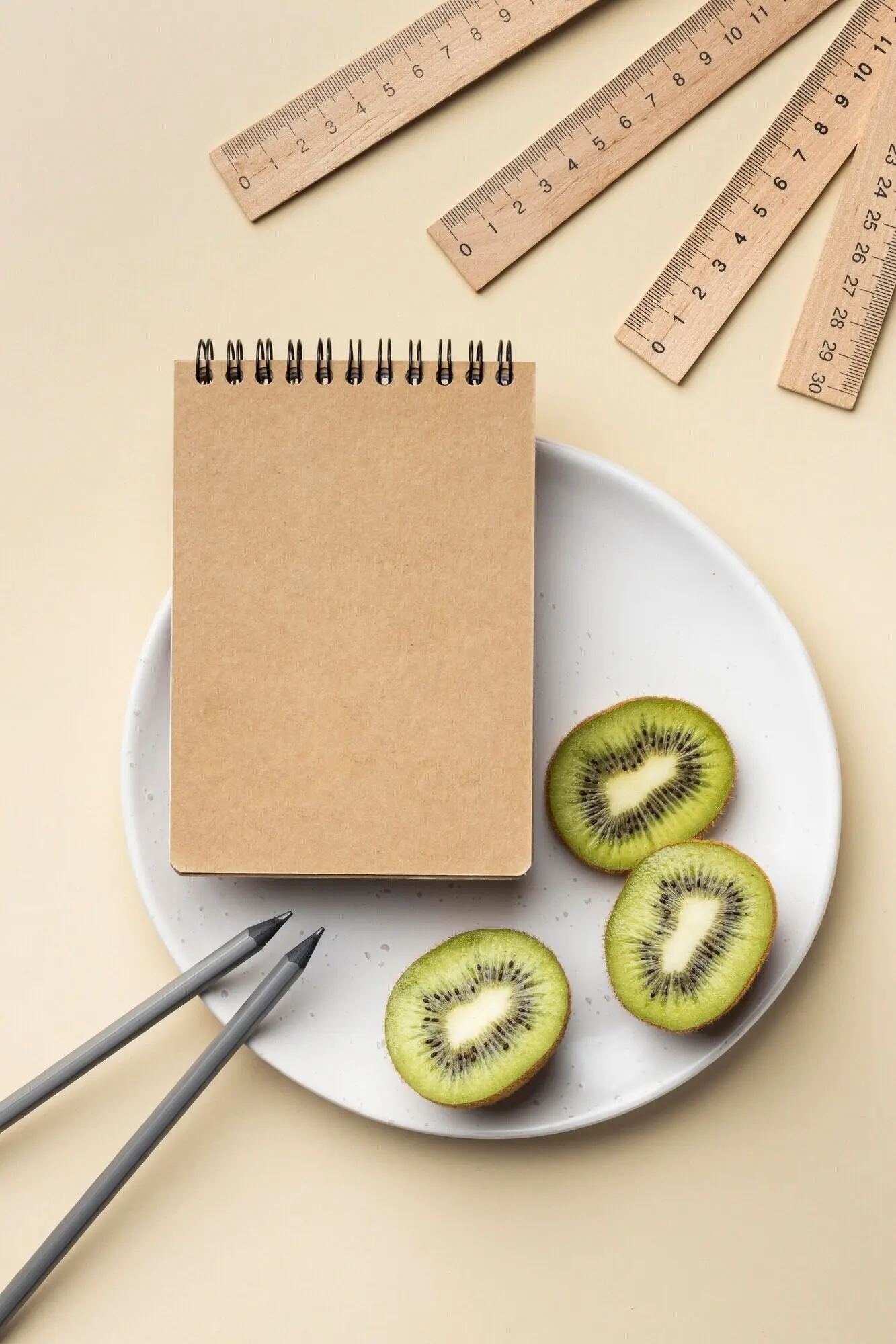 Komposition mit Schreibwaren-Elementen auf beigem Grund